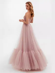 Elegant dusty pink strapless tulle evening gown with a lace-up back and voluminous skirt