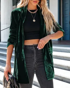 Detail shot of a luxurious dark green velvet long sleeve cardigan with lapel collar.
