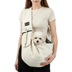 Detail of cream quilted pet carrier sling bag featuring small dog and interior lining