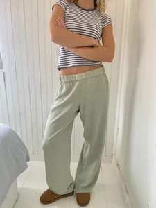 Lässige, hellgrüne Hose mit hoher Taille und Streifen-Shirt in gemütlicher Wohnumgebung
