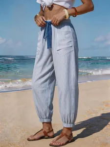 Detailed view of blue and white striped linen-look joggers featuring drawstring and pockets.