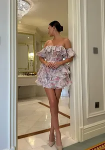 Full-length shot of a floral tiered ruffle off-the-shoulder dress worn in a luxury setting