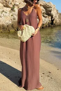 Full-length view of a solid brown loose-fit vacation dress on a sunny beach.