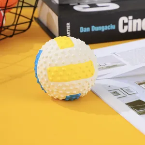 Detailed view of white latex squeaky dog ball toy with yellow stripes and textured bumps.