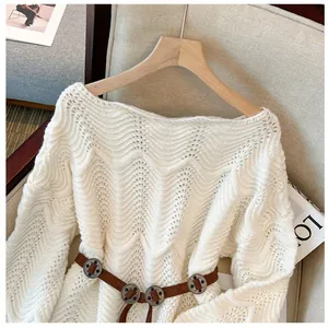 Detailansicht eines weißen Lochstrickpullovers mit schickem braunem Gürtel-Accessoire.