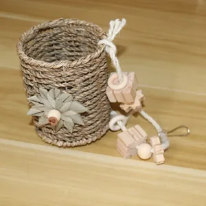 Detailed view of handmade woven straw bird nest toy with wooden blocks and cotton rope
