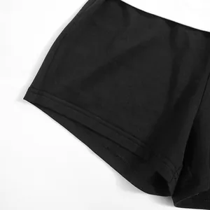 Gros plan détaillé sur les doubles surpiqûres de l'ourlet du short moulant noir