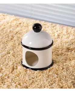 Vue détaillée de la cachette igloo en céramique blanche pour hamsters sur copeaux