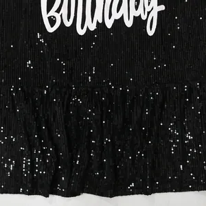 Close-up of black sequined dress detail with ruffled lotus leaf hem design