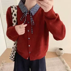Vue détaillée d'un cardigan en tricot rouge avec col de chemise à carreaux et nœud