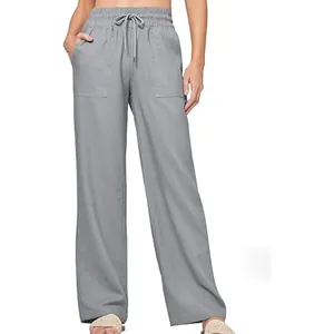Detail of grey high-waisted linen wide-leg pants featuring drawstring and patch pockets