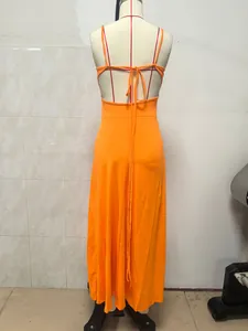 Detalle de la espalda de un vestido largo naranja sin espalda en un maniquí con cordones.