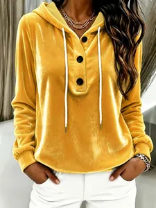 Close-up of stylish yellow gold velvet hooded sweatshirt featuring buttons and a white drawstring