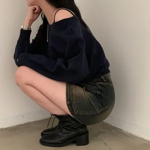 Dettaglio profilo di un elegante maglione in maglia blu scuro con spalle scoperte