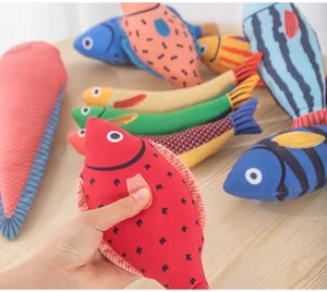 Detailansicht einer Hand, die ein buntes rotes Plüschfisch-Spielzeug für Katzen hält.