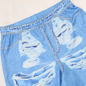 Gros plan d'un pantalon bleu imprimé denim avec des coutures factices et des motifs.