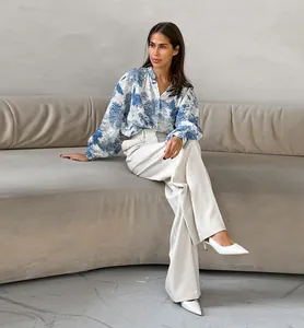 Blue and white floral mandarin collar blouse with lantern sleeves and white trousers