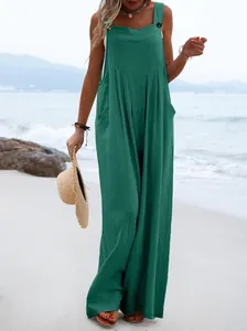 Detalle de mono verde de pierna ancha con botones en escena de playa de verano
