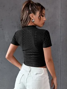 Vue arrière d'un crop top noir à col montant en mesh avec de jolis motifs en dentelle.