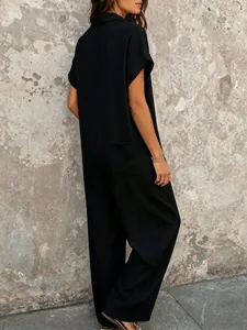 Back view detail showing the textured fabric of a loose black short sleeve jumpsuit.