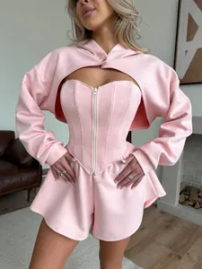 Vista detallada del conjunto rosa de tres piezas con sudadera corta y corsé.