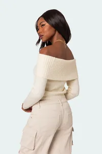 Detail view of a cream off-the-shoulder knit sweater with soft ribbed trim