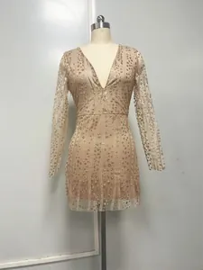 Detailed shot of the shimmering gold-sequined fabric on a sexy deep V-neck long-sleeve dress