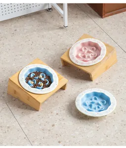 Vista dettagliata delle ciotole slow feeder in ceramica blu e rosa con supporti in bambù