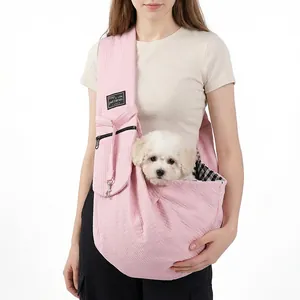 Close-up detail of a pink quilted pet sling carrier with a small white dog inside