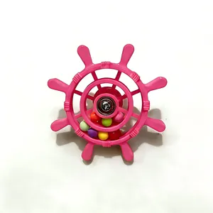 Close-up view of a pink bird cage ship wheel toy with colorful rolling beads for parrots