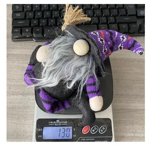 Halloween faceless witch gnome doll with striped legs weighing 130 grams on scale