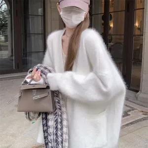 Soft white faux mink fur cardigan worn by a model in an outdoor urban setting environment