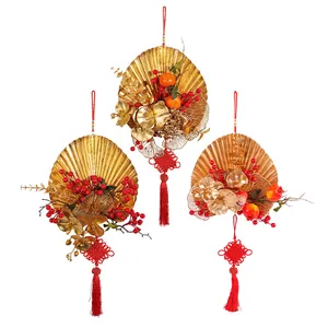 Festive 2026 Chinese New Year gold fan wall hangings with red berries and tassels.