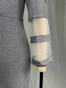 Detaillierte Nahaufnahme eines silbernen Glitzer-Abendkleids mit Mesh-Ärmeleinsätzen