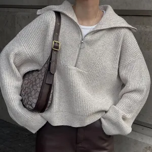 Close-up of a vintage beige oversized knit sweater featuring a stylish quarter-zip collar