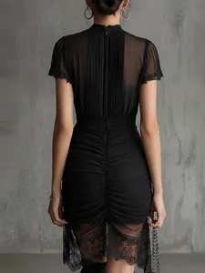 Back view detail of a black slim-fit dress with sheer lace patchwork and pleats
