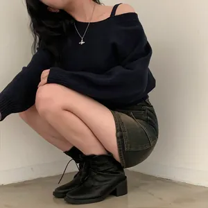 Vista dettagliata di un maglione in maglia blu scuro con spalle scoperte e vestibilità