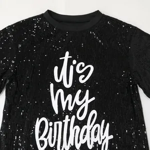 Detail showing sequined texture and 'it's my Birthday' print on black dress