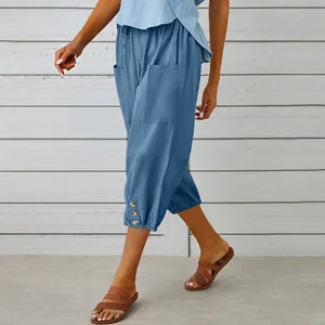 Detail view of blue cotton-linen cropped pants with drawstring waist and buttoned hem