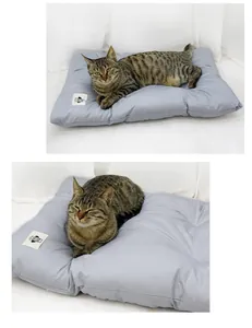 Detailansicht einer weichen grauen Baumwoll-Haustiermatte mit einer liegenden getigerten Katze