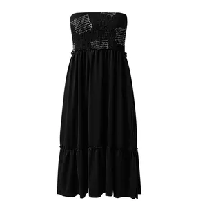 Close-up of black strapless midi dress with white scribbled print and pleated chest.