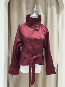 Vista frontale di un elegante trench corto bordeaux con collo alto e cintura in vita