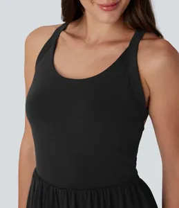 Close-up of sleeveless black summer dress featuring a round neckline and pleated waist