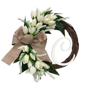 Detailed view of artificial white tulip wreath with burlap bow and white letter C
