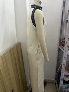 Détail de profil d'une combinaison en lin beige sans manches avec col montant imprimé