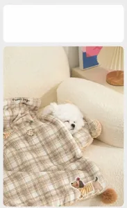 Cozy plaid pet blanket and pillow set featuring a sleeping white puppy in a home setting