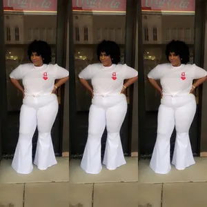 Stylish plus size woman wearing white flared bell-bottom trousers and heart print t-shirt