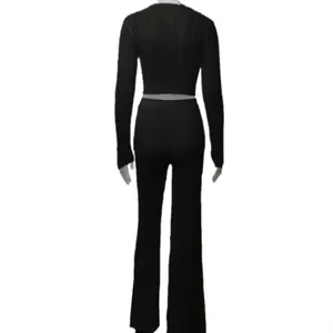 Back view of a black ribbed knit set with a long sleeve top and flared trousers