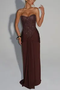 Detail view of an elegant brown sequined corset gown with a draped floor-length skirt
