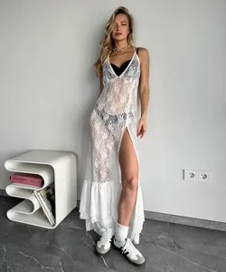 Detail view of a white lace sheer V-neck maxi dress worn by a model in a modern room